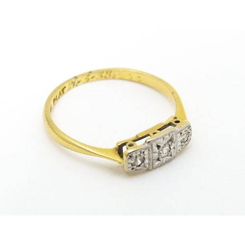 588 - An Art Deco 18ct gold and platinum ring. set with three diamonds. Ring size approx. J.