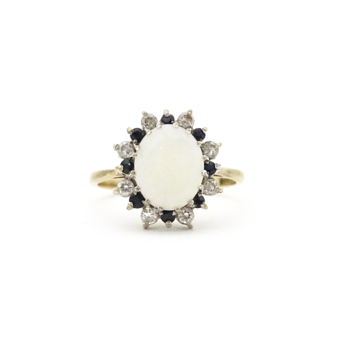 592 - A 9ct gold ring set with central opal cabochon bordered by blue and white stones. Ring size approx. ... 