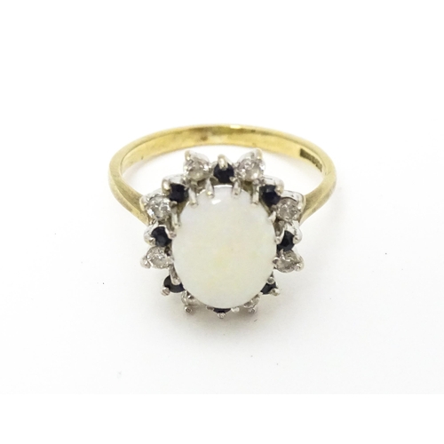 592 - A 9ct gold ring set with central opal cabochon bordered by blue and white stones. Ring size approx. ... 