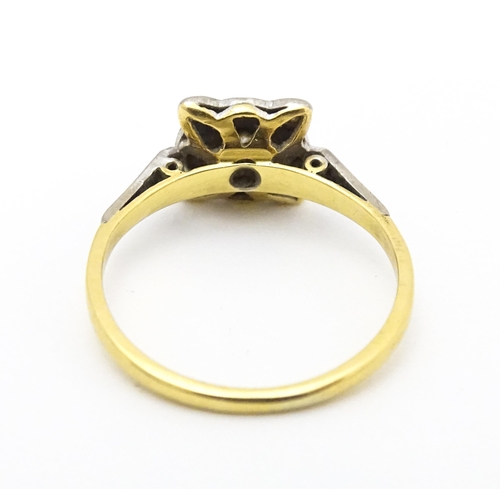 596 - An 18ct gold ring with platinum set diamonds. Ring size approx. M