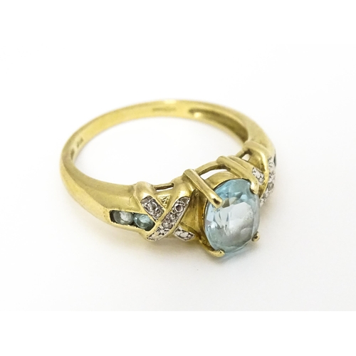 600 - A 9ct gold ring set with aquamarine and diamond. Ring size approx. O