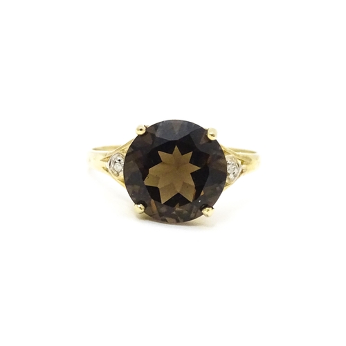 604 - A 9ct gold ring set with smoky topaz and diamonds. Ring size approx. M