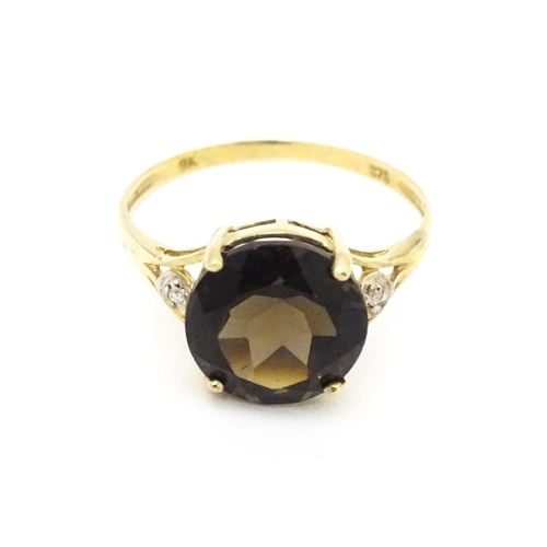 604 - A 9ct gold ring set with smoky topaz and diamonds. Ring size approx. M