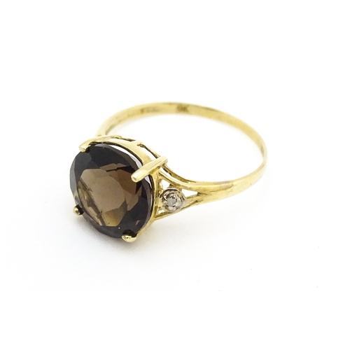 604 - A 9ct gold ring set with smoky topaz and diamonds. Ring size approx. M