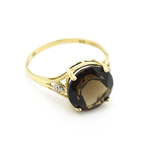 604 - A 9ct gold ring set with smoky topaz and diamonds. Ring size approx. M