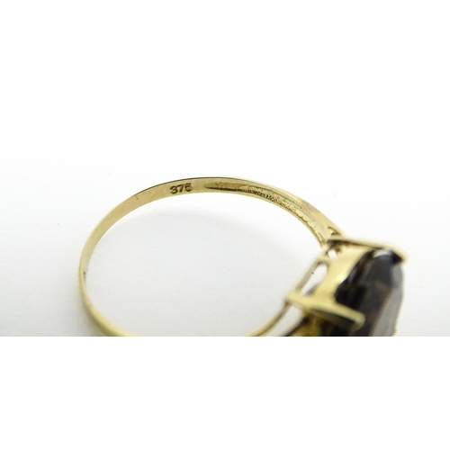 604 - A 9ct gold ring set with smoky topaz and diamonds. Ring size approx. M