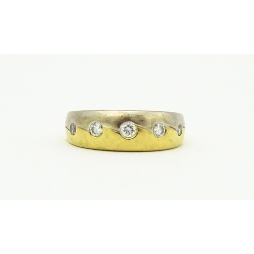 608 - An 18ct white and yellow gold ring set with five diamonds. Ring size approx L