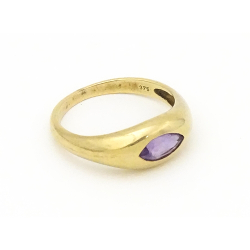 612 - A 9ct gold ring set with central marquise cut amethyst. Ring size approx. N