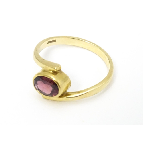 613 - A 9ct gold ring set with oval garnet. Ring size approx. Q