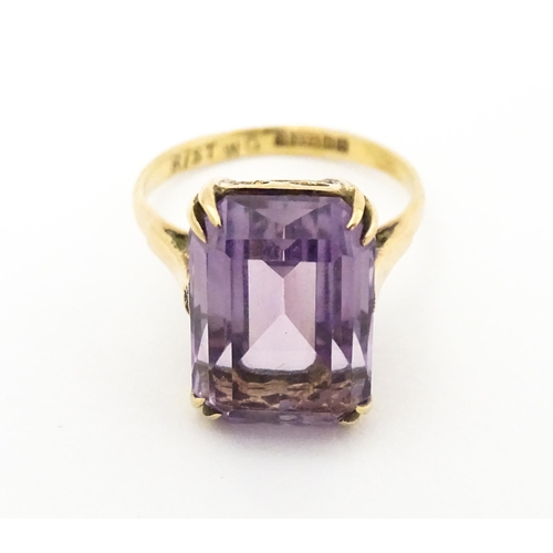 620 - A 9ct gold dress ring set with central amethyst. Ring size approx. J 1/2