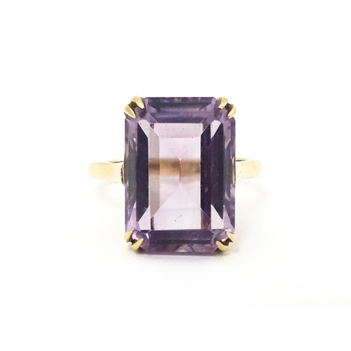 620 - A 9ct gold dress ring set with central amethyst. Ring size approx. J 1/2