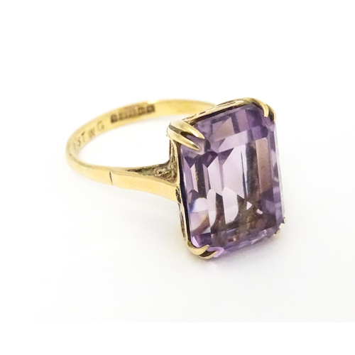 620 - A 9ct gold dress ring set with central amethyst. Ring size approx. J 1/2