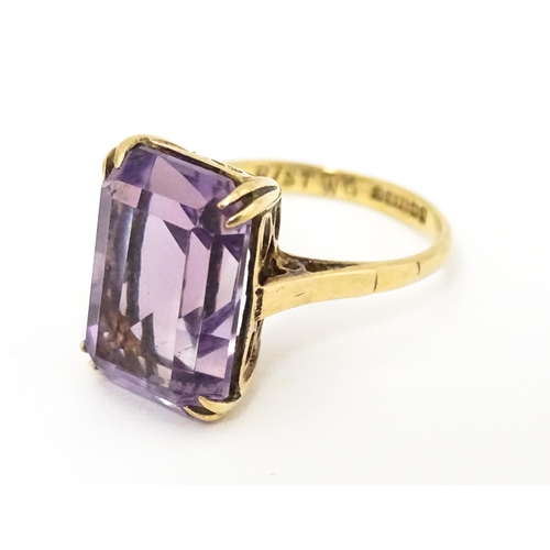 620 - A 9ct gold dress ring set with central amethyst. Ring size approx. J 1/2