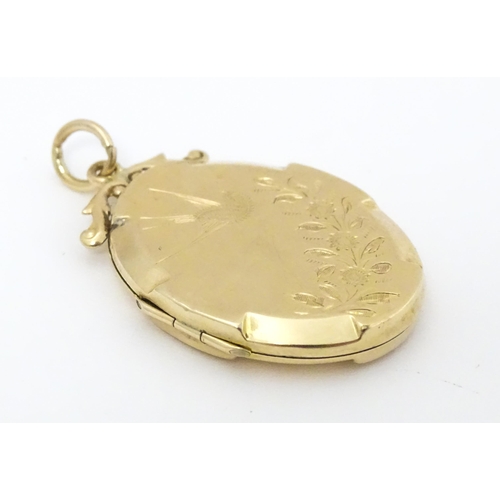 643 - A 9ct gold back & front locket of oval form with engraved swallow and forget-me-knot detail. Approx.... 