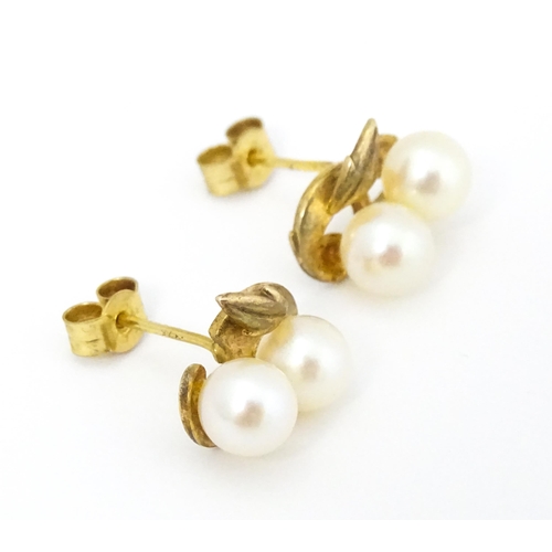 658 - A pair of 9ct gold stud earrings with double pearl detail. Approx. 1/2