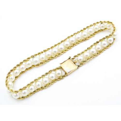 666 - A 14ct gold bracelet set with band of pearls. Approx. 7