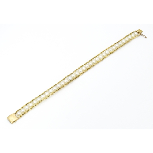 666 - A 14ct gold bracelet set with band of pearls. Approx. 7