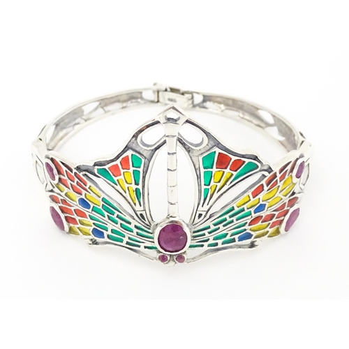 690 - A silver bracelet with dragon fly detail decorated with Plique a jour style detail and red stones.