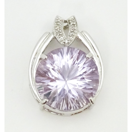 694 - A 9ct white gold pendant set with diamonds and central pale stone. Approx. 1