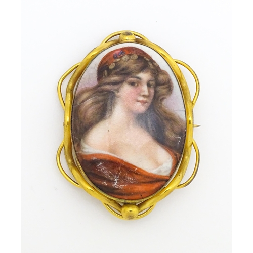 699 - A gilt metal brooch set with central ceramic cabochon with hand painted Pre-Raphaelite style maiden.... 