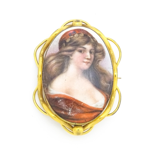 699 - A gilt metal brooch set with central ceramic cabochon with hand painted Pre-Raphaelite style maiden.... 