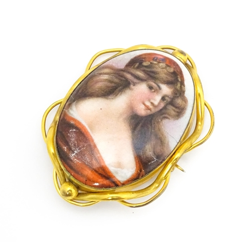 699 - A gilt metal brooch set with central ceramic cabochon with hand painted Pre-Raphaelite style maiden.... 