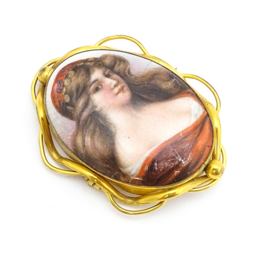 699 - A gilt metal brooch set with central ceramic cabochon with hand painted Pre-Raphaelite style maiden.... 