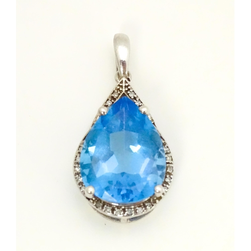 706 - A 9ct white gold pendant set with central topaz bordered by diamonds. Approx. 1