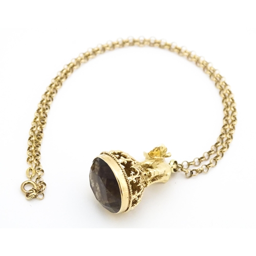 770 - A 9ct gold pendant fob seal surmounted by an elephant and set with facet cut smoky quartz under, on ... 