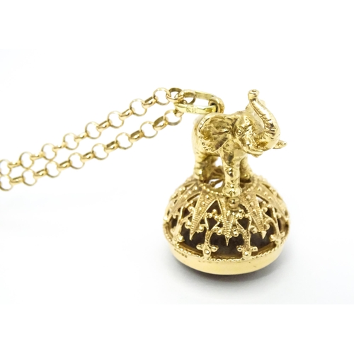 770 - A 9ct gold pendant fob seal surmounted by an elephant and set with facet cut smoky quartz under, on ... 