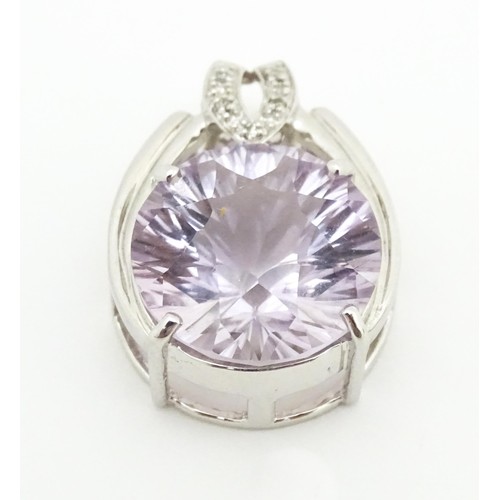 694 - A 9ct white gold pendant set with diamonds and central pale stone. Approx. 1