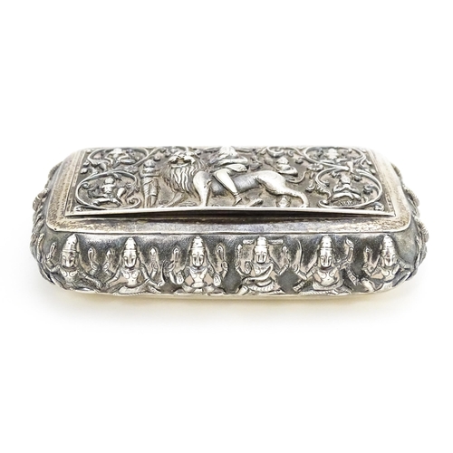 522 - A white metal snuff box decorated with various deities, including one to centre depicting a deity ri... 