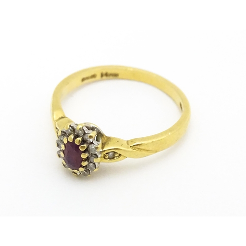 568 - An 18ct gold ring set with central ruby bordered by diamonds. Ring size approx. M 1/2.