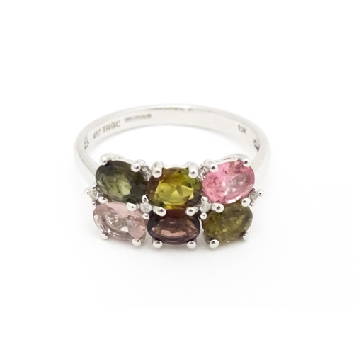 575 - A 9ct white gold ring set with diamonds and various coloured stones. Ring size approx. L