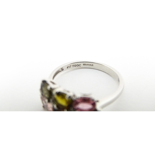 575 - A 9ct white gold ring set with diamonds and various coloured stones. Ring size approx. L