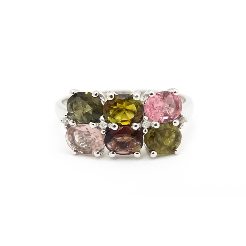 575 - A 9ct white gold ring set with diamonds and various coloured stones. Ring size approx. L