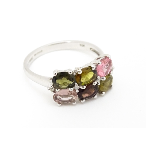 575 - A 9ct white gold ring set with diamonds and various coloured stones. Ring size approx. L