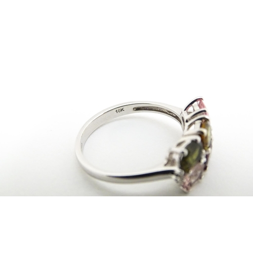 575 - A 9ct white gold ring set with diamonds and various coloured stones. Ring size approx. L