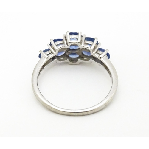 594 - A 9ct white gold ring set with blue stones. Ring size approx. N