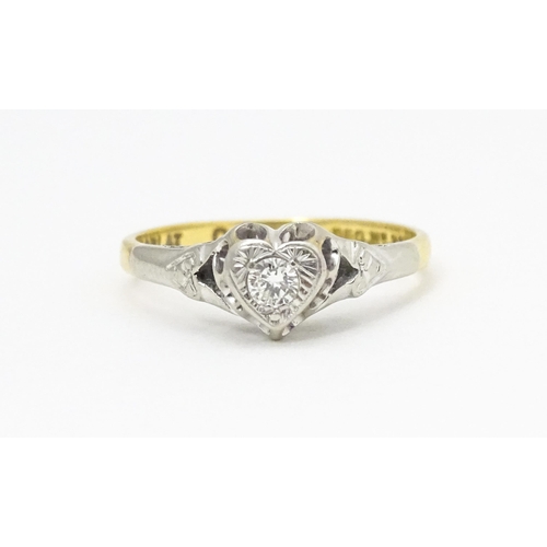 599 - An 18ct gold ring with platinum set diamond within a heart shaped setting, marked with registration ... 