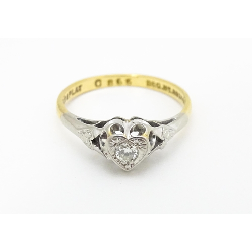 599 - An 18ct gold ring with platinum set diamond within a heart shaped setting, marked with registration ... 