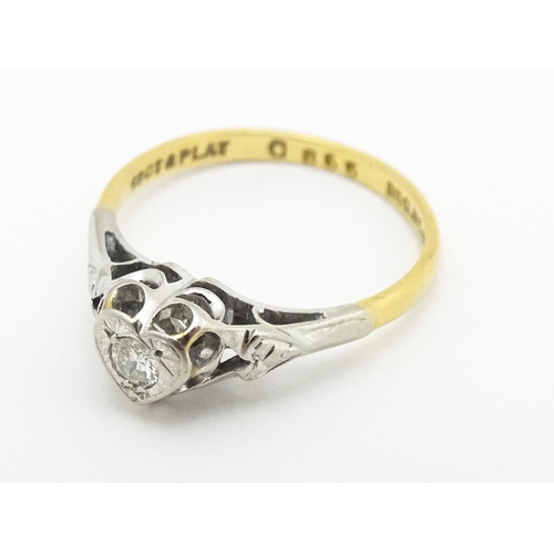 599 - An 18ct gold ring with platinum set diamond within a heart shaped setting, marked with registration ... 