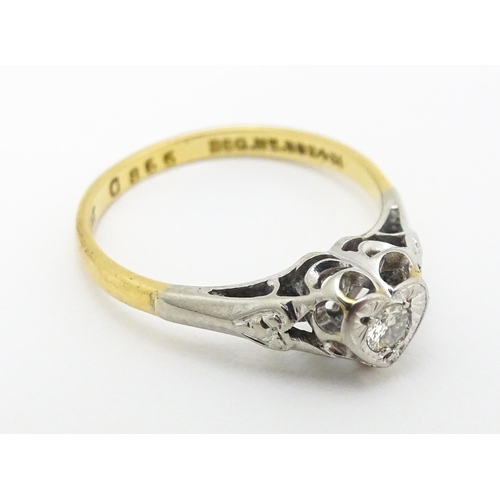 599 - An 18ct gold ring with platinum set diamond within a heart shaped setting, marked with registration ... 