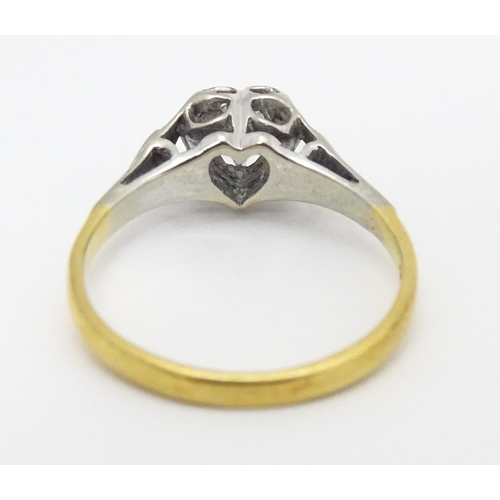 599 - An 18ct gold ring with platinum set diamond within a heart shaped setting, marked with registration ... 