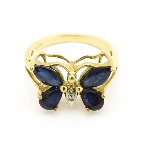 605 - A 9ct gold ring set with sapphires and diamond in a butterfly setting. Ring size approx. M 1/2