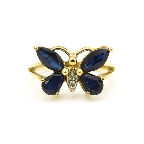 605 - A 9ct gold ring set with sapphires and diamond in a butterfly setting. Ring size approx. M 1/2