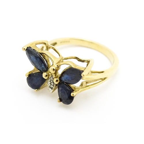 605 - A 9ct gold ring set with sapphires and diamond in a butterfly setting. Ring size approx. M 1/2