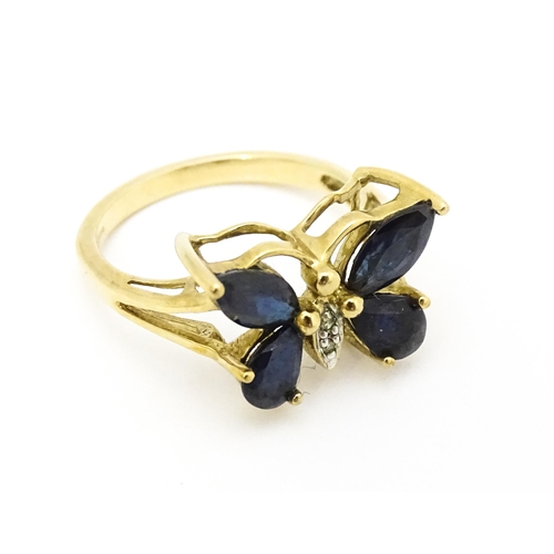 605 - A 9ct gold ring set with sapphires and diamond in a butterfly setting. Ring size approx. M 1/2