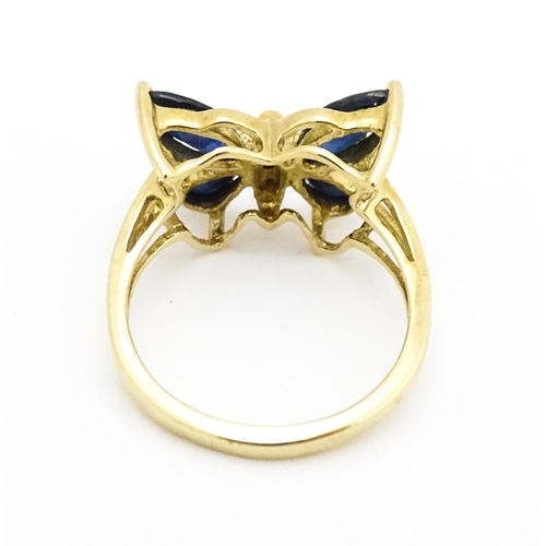 605 - A 9ct gold ring set with sapphires and diamond in a butterfly setting. Ring size approx. M 1/2