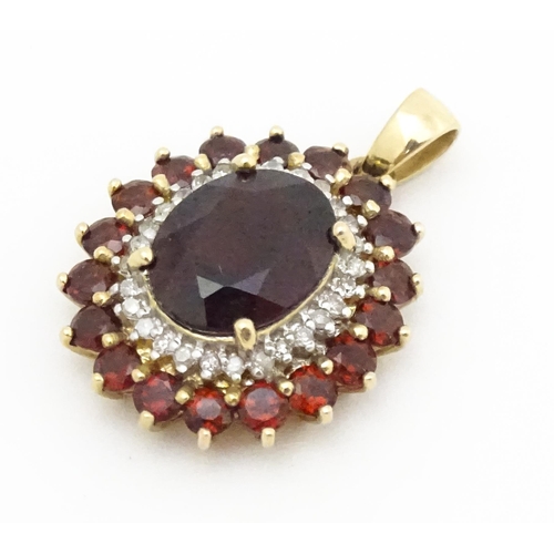 626 - A 9ct gold pendant set with garnets and diamonds. Approx. 3/4